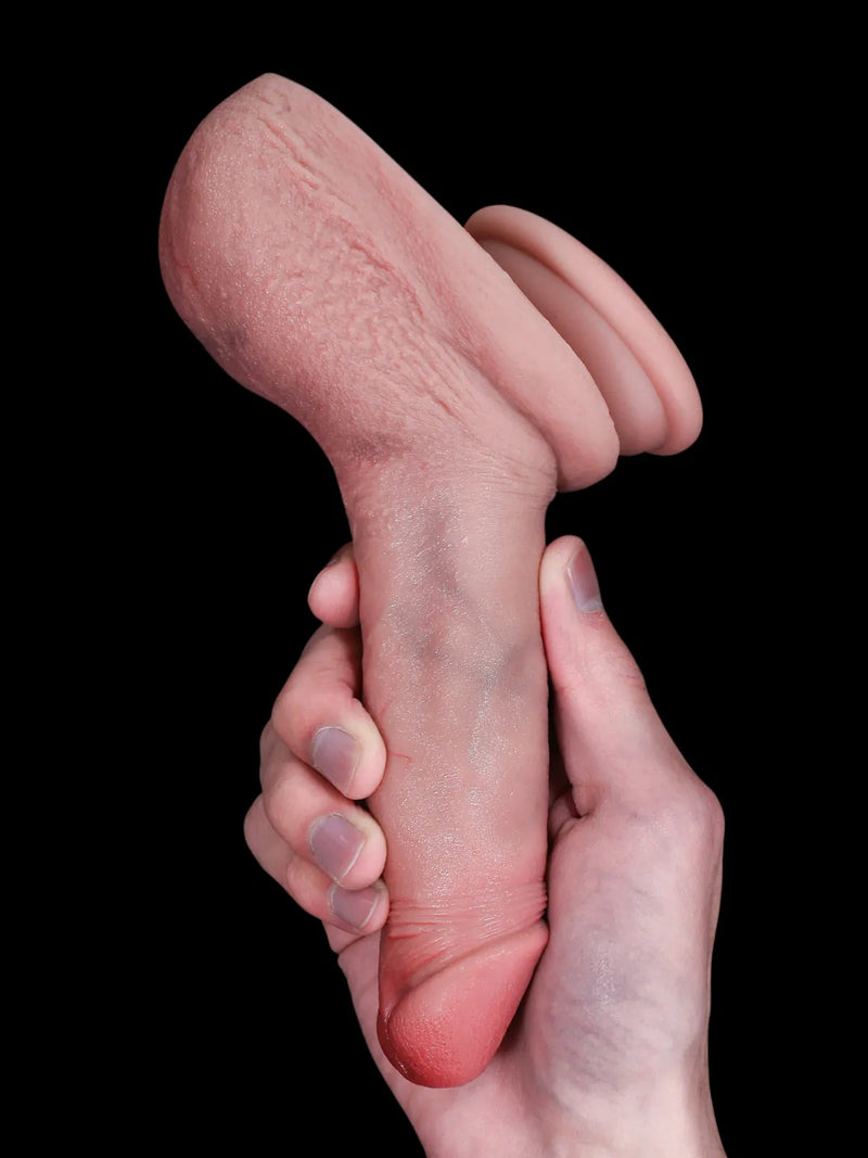 Mini flesh dildo held in hand, dark background