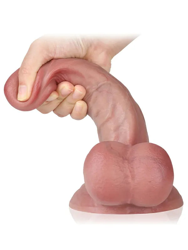 Soft realistic flesh dildo held and flexed in hand